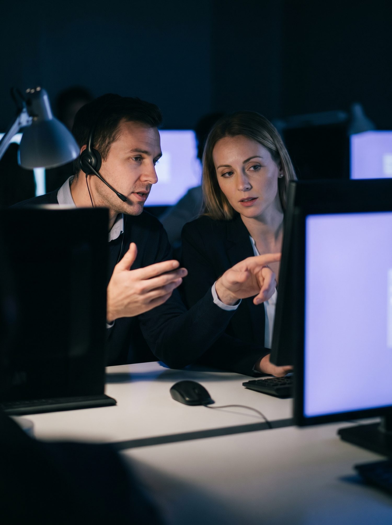 Call agent working calmly at night, lit by her screen
